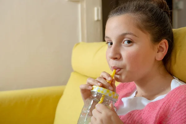 Een Jonge Tiener Meisje Zit Een Gele Bank Drinken Sinaasappelsap — Stockfoto