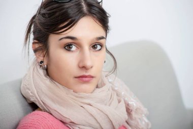 kanepede içinde oturan bir genç esmer kadın