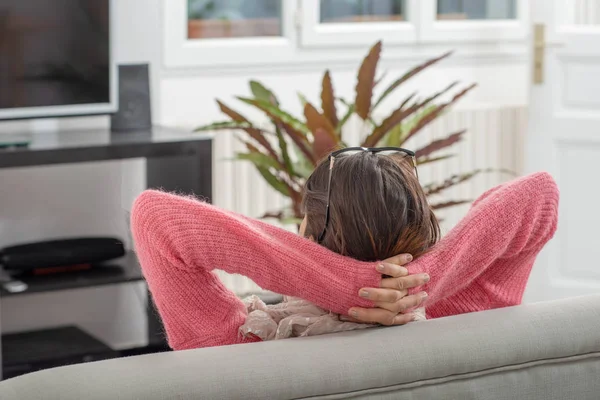 Una Giovane Donna Bruna Con Maglione Rosa Appoggiata Sul Divano — Foto Stock