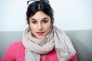 kanepede içinde oturan bir genç esmer kadın