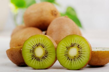 Beyaz ahşap bir masa üzerinde kivi