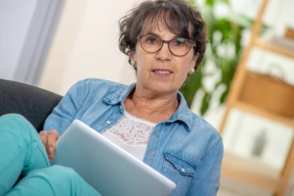 Una Encantadora Morena Senior Con Gafas Usando Tableta Digital Casa —  Fotos de Stock