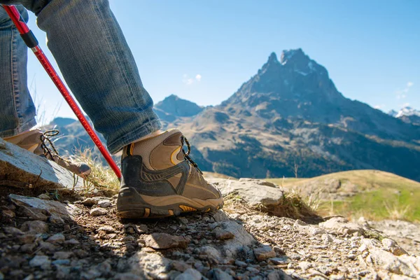 a close up of hiker shoes the Pic Ossau on background