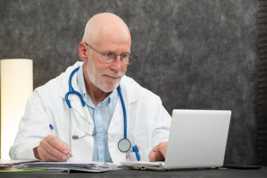 Üst düzey bir doktor tıbbi ofis oturma portre