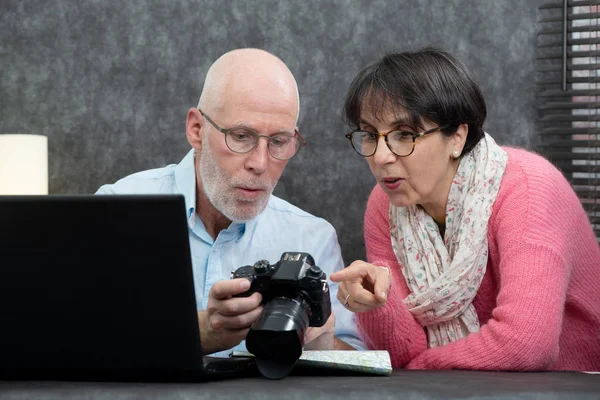 Senior couple watching vacation pictures on camera — Stock Photo, Image