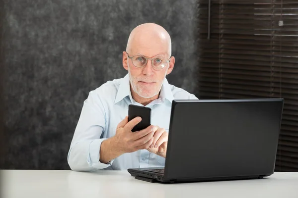 Senior businessman reading message to smartphone — Stock Photo, Image