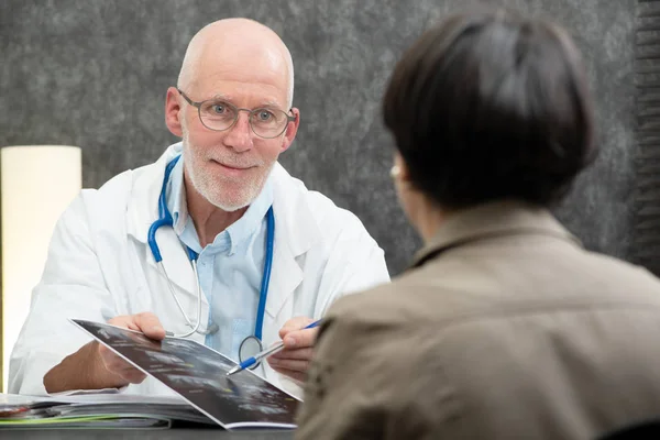 Senior arts tonen xray op patiënt — Stockfoto