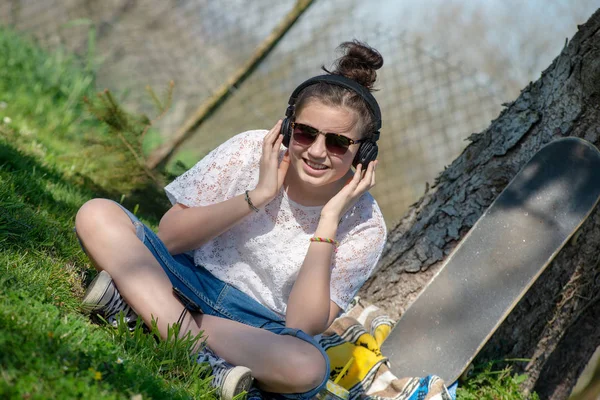 Mladá dospívající dívka se slunečními brýlemi, poslech hudby, venkovní — Stock fotografie