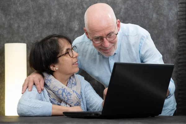 Happy senior couple using laptop at home — Stock Photo, Image