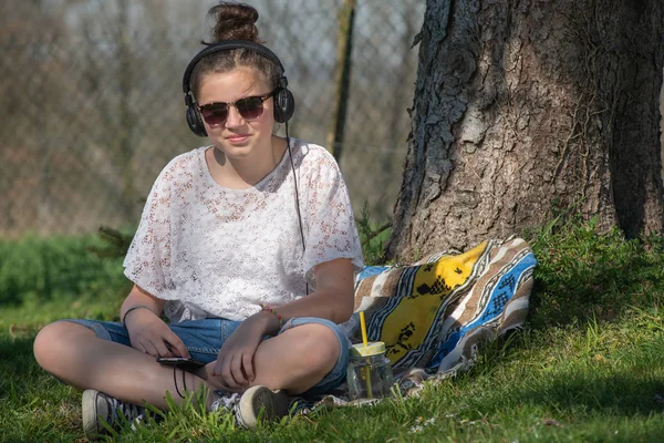 Mladá dospívající dívka se slunečními brýlemi, poslech hudby, venkovní — Stock fotografie