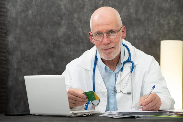 Médico barbudo sênior com cartão de seguro de saúde — Fotografia de Stock