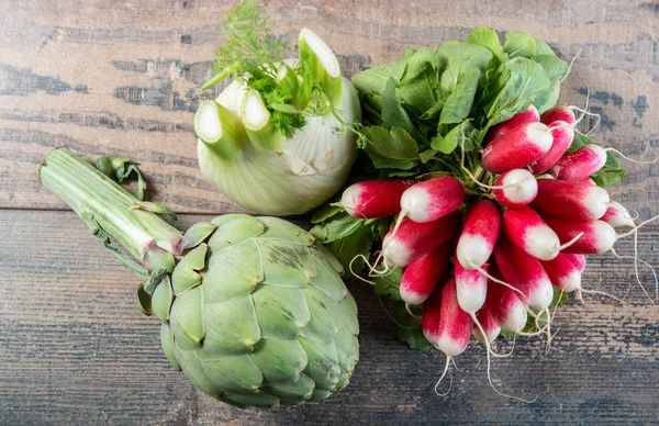 Artichokes, fennel and radishes on  wooden table — Stock Photo, Image