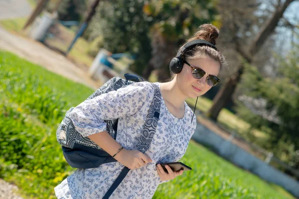 Young teenager girl with sunglasses listening music outdoor — Stock Photo, Image