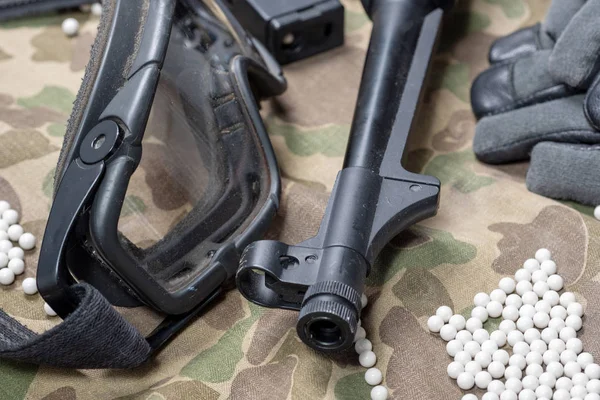 Airsoft gun with protective glasses and lot of bullets — Stock Photo, Image