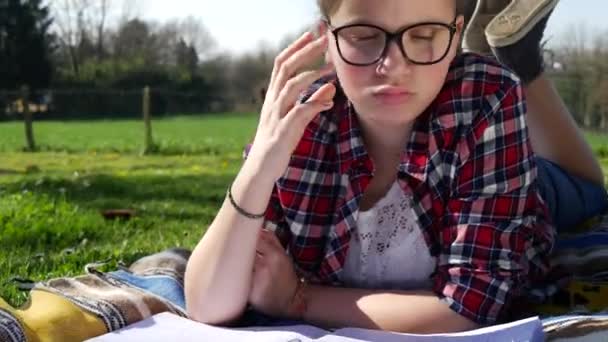 Adolescente Haciendo Tarea Jardín Acostado Hierba — Vídeo de stock