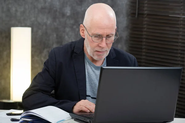 Senior avec barbe et chemise bleue dans le bureau à l'aide d'un ordinateur portable — Photo