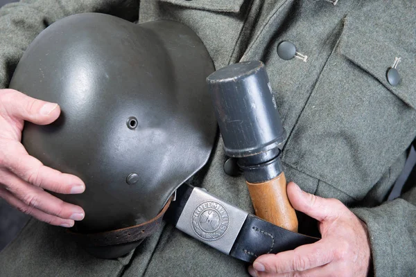 Opasek, granát a přilba německého vojáka ve svěrací kazajce s — Stock fotografie