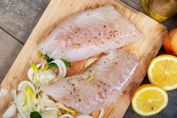 Peixe fresco, filetes de bacalhau crus com adição de ervas e limão — Fotografia de Stock