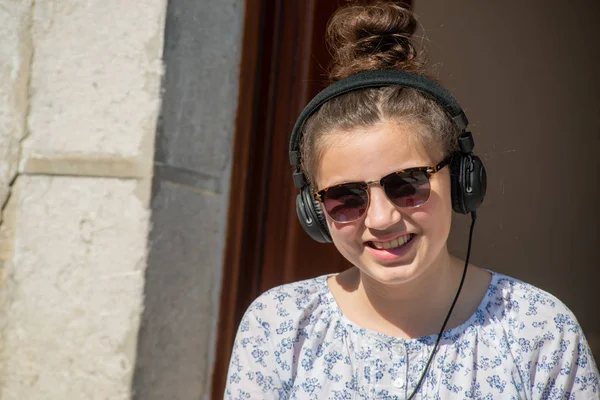 Joven adolescente chica con gafas de sol escuchar música al aire libre — Foto de Stock
