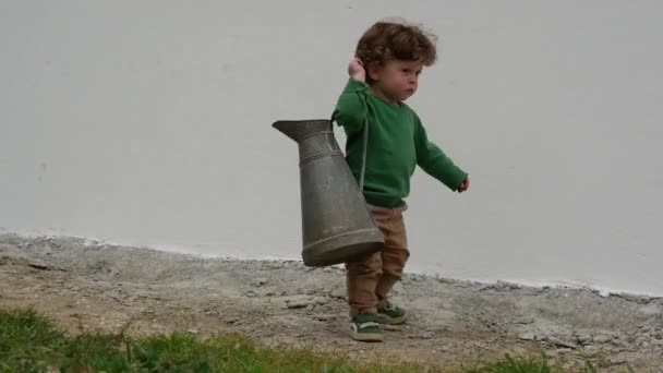 Αστείο Νεαρό Αγόρι Πράσινο Πουλόβερ Παίζοντας Παλιά Κανάτα Εξωτερικούς Χώρους — Αρχείο Βίντεο