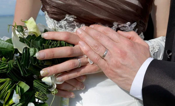 Händer och ringar på bröllopsbukett — Stockfoto