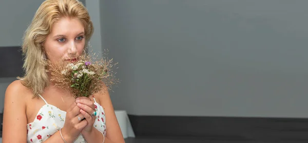 Portret van mooie jonge blonde vrouw met boeket bloemen — Stockfoto