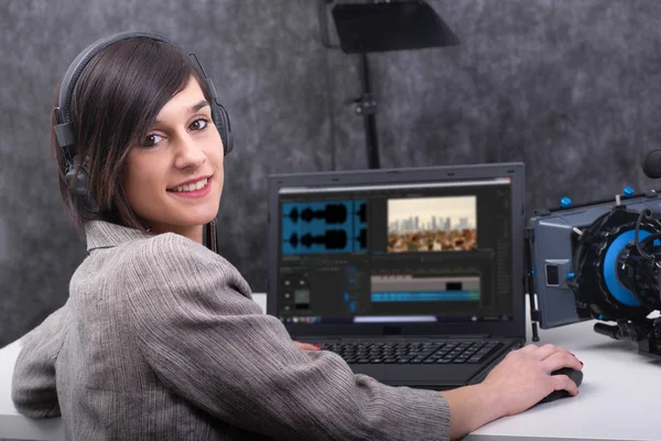 Jeune femme souriante monteur vidéo travaillant en studio — Photo
