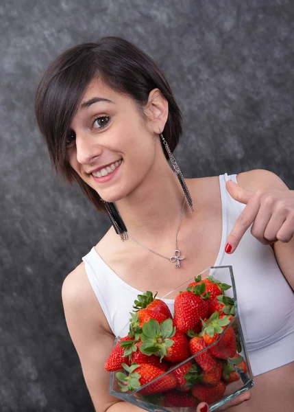 Jolie jeune femme brune manger fraise — Photo