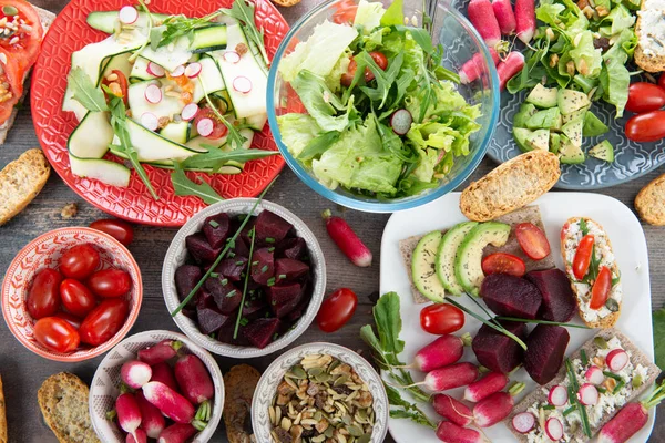 Bols et assiette de salade végétalienne saine. Divers légumes avoc — Photo