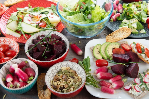 Bols et assiette de salade végétalienne saine. Divers légumes avoc — Photo