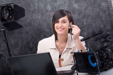 gülümseyen genç kadın video editörü stüdyoda bir sd kart gösteren