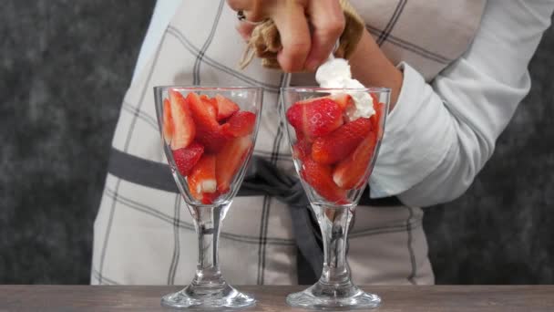 イチゴとホイップクリームのグラス2杯が上部に絞り出される — ストック動画