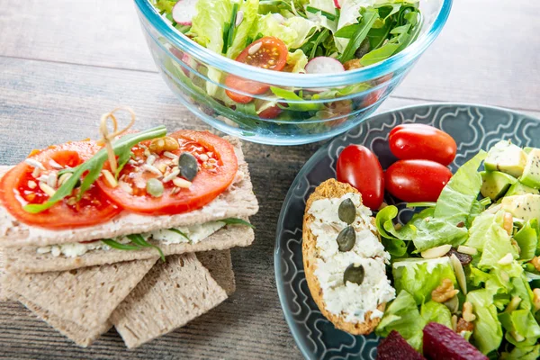 Bols et assiette de salade végétalienne saine. Divers légumes sur wo — Photo