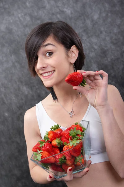 Bonita jovem morena mulher comer morango — Fotografia de Stock