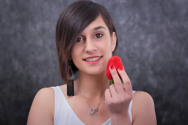 Bella giovane donna bruna mangiare fragola — Foto Stock