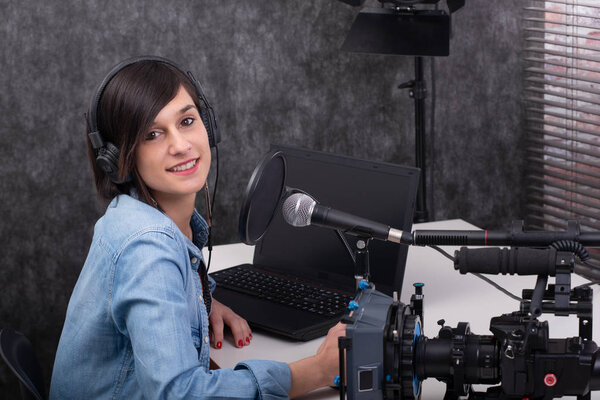 Young woman video editor working in studio