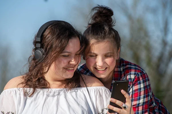 Retrato de dos hermanas felices con smartphone, al aire libre — Foto de Stock