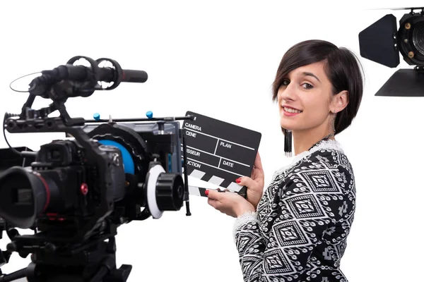Una giovane donna con una clapboard in mano. videocamera, sul retro bianco — Foto Stock