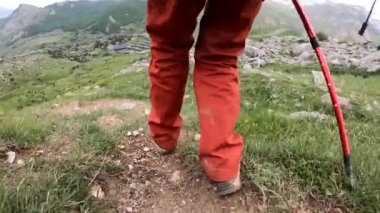 Dağlarda yürüyüş trekking. Bir sırt çantası ile yol boyunca yürüyen kadının arka görünümü 
