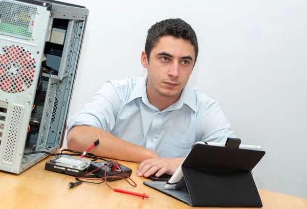 Počítač pro opravy mladého muže — Stock fotografie
