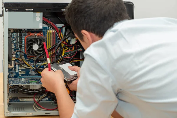 Počítač pro opravy mladého muže — Stock fotografie
