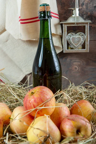 Fles cider met appels op het stro — Stockfoto