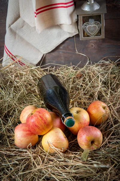 Flasche Apfelwein mit Äpfeln auf dem Stroh — Stockfoto