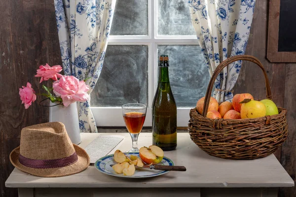 Bottle and glass of cider with apples. In rustic house — Stock Photo, Image