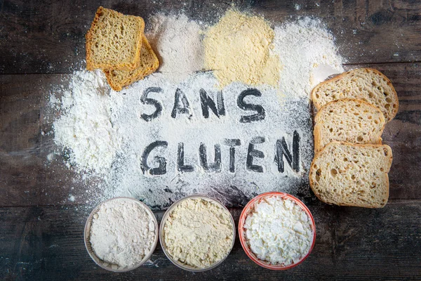 gluten-free (sans gluten) bread and flour on wooden background