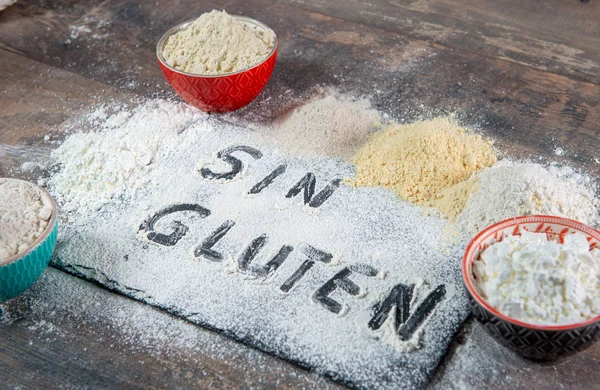 gluten-free (sin gluten) flour on wooden background