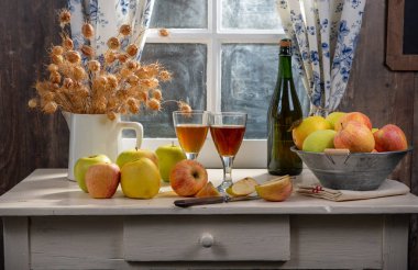 Masanın üzerinde elma olan şişe ve bardak elma şarabı. Kırsal kesimde