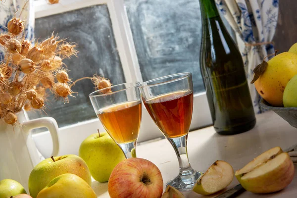 Botella y vasos de sidra con manzanas. En casa rústica, ventana — Foto de Stock