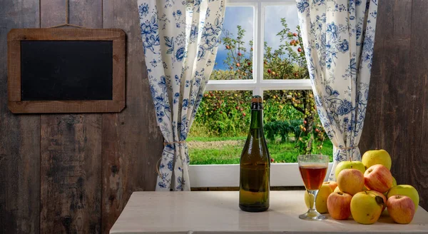 Bottle and glass of cider with apples. near the window — Stock Photo, Image