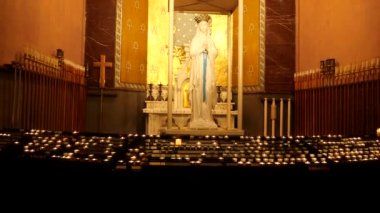 Lourdes kilisesinde mumlar, dini semboller.